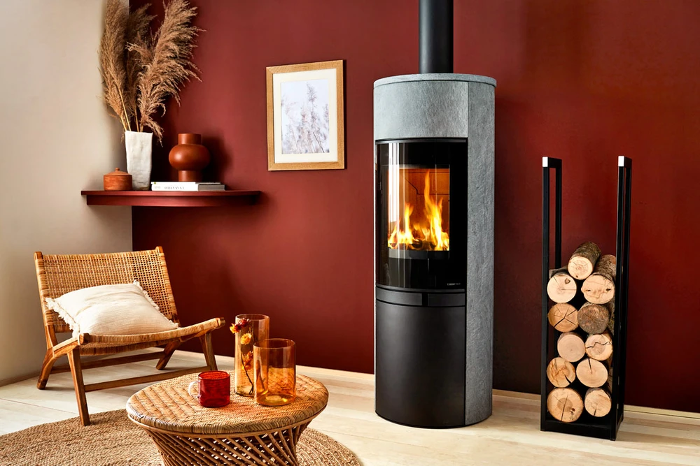 Intérieur résidentiel avec poêle à bois noir en fonctionnement, flammes visibles à travers la vitre