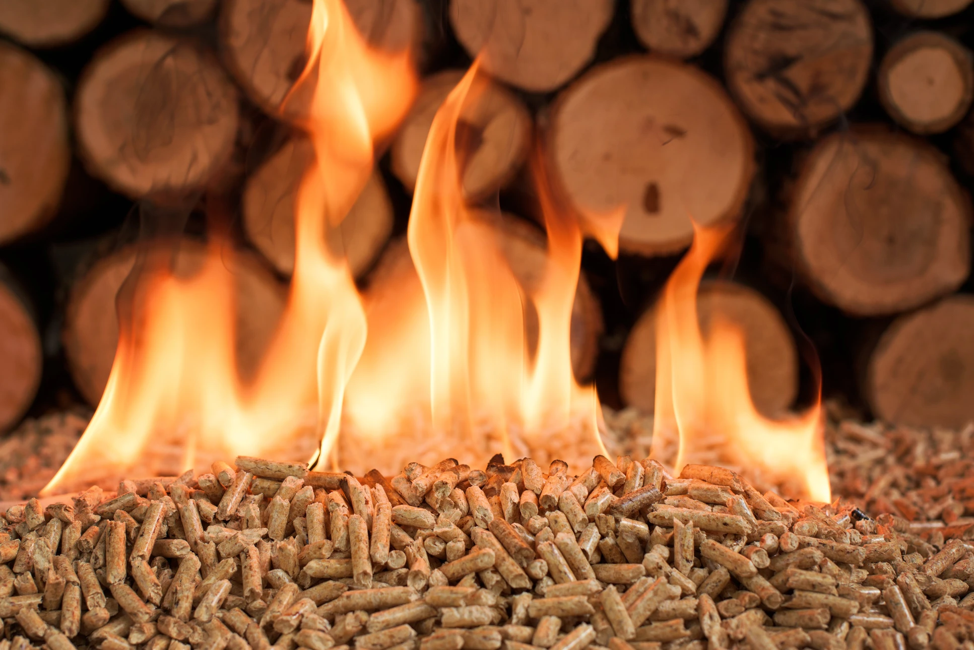 Scène extérieure montrant un foyer de combustion avec flammes vives s'élevant de granulés de bois