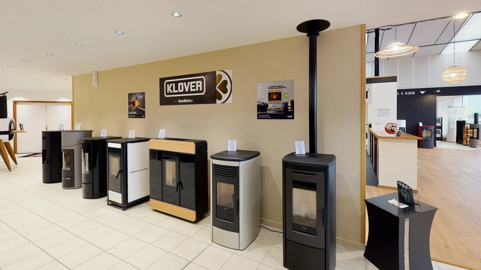 Showroom intérieur présentant plusieurs poêles à granulés de différents modèles disposés sur parquet bois